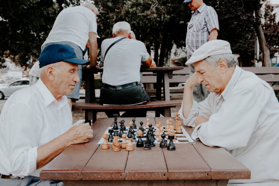 Duas pessoas jogando xadrez, uma das quais é um jogo de xadrez.